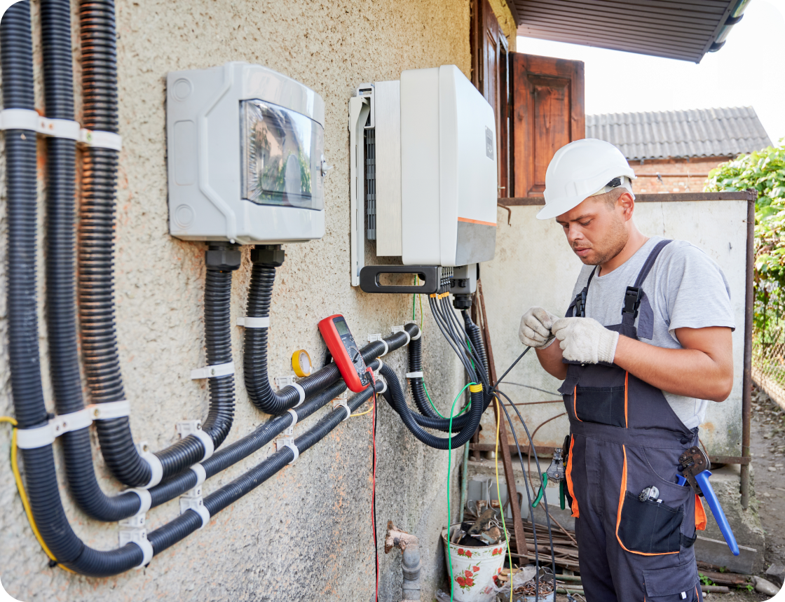 Electrician working on outdoor electrical installation.